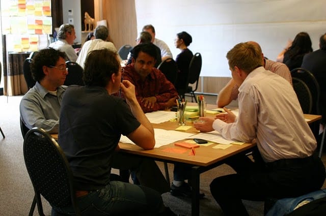 Mensen aan een tafel in gesprek tijdens een duurzaamheidsworkshop