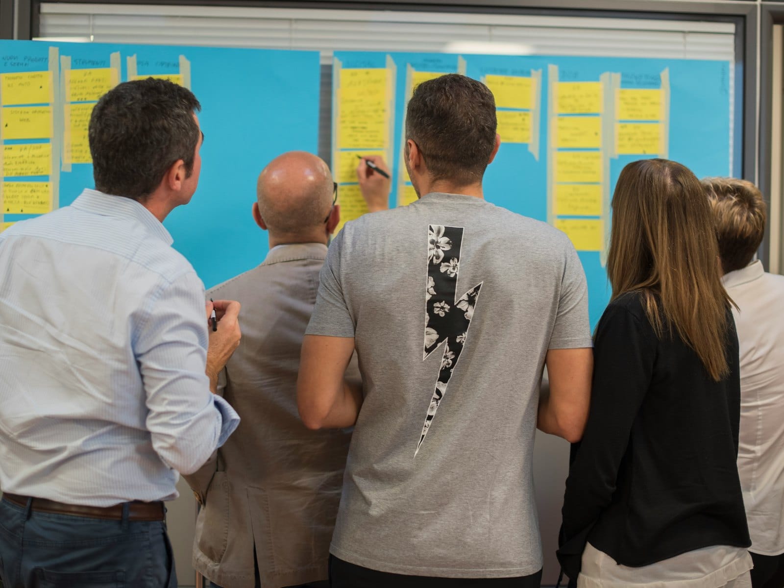 Team van een gemeente werkt tijdens een werksessie aan een wand vol post-its