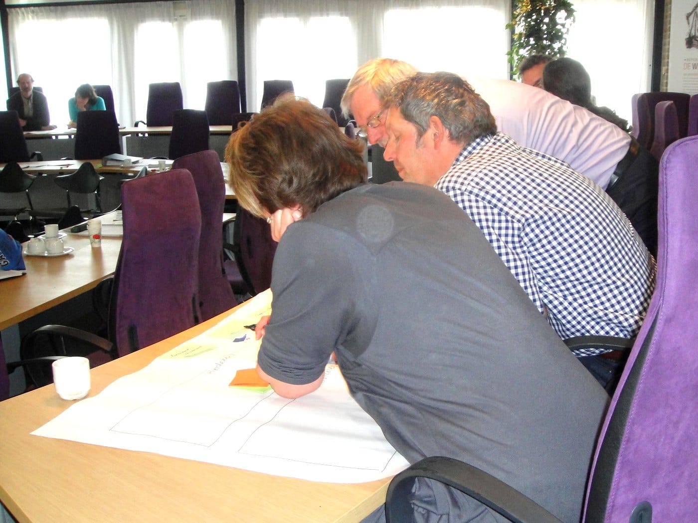 Deelnemers werken samen aan een concrete vraag tijdens een werksessie.